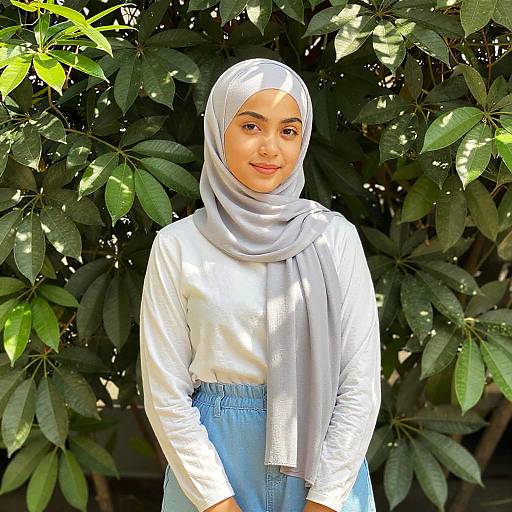 Young Woman in Gray Hijab Standing by Green Plants
