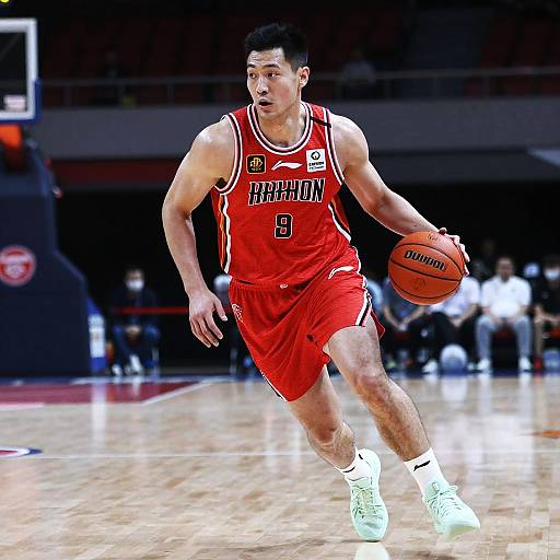 Male Basketball Player Dribbling in Red Jersey on Court