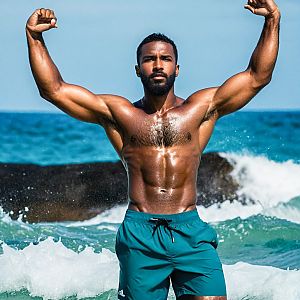 Muscular Man Flexing in Ocean Waves