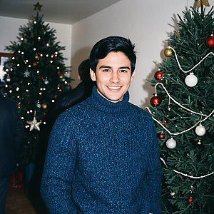 Young Man Smiling by Christmas Tree