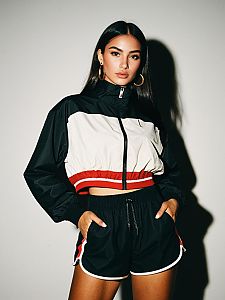 Woman in Sporty Chic Cropped Color Block Windbreaker Jacket and Athletic Shorts
