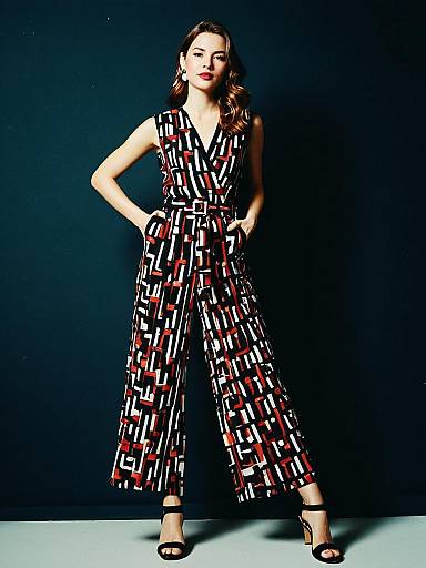 Woman in Modern Graphic Sleeveless Jumpsuit with Abstract Red and White Pattern
