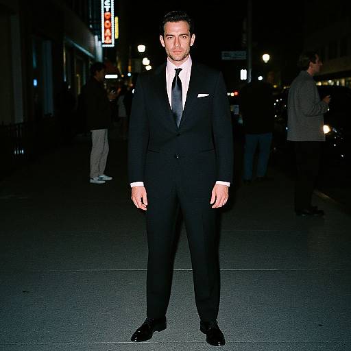 Man in Black Suit Standing on Urban Street at Night