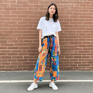 Fashionable Woman in Colorful Outfit Against Brick Wall
