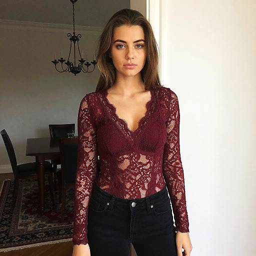 Woman Wearing Burgundy Lace Top and Black Jeans Indoor Fashion Portrait