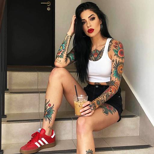 Tattooed Woman in White Crop Top and Red Adidas Sneakers Sitting with Iced Coffee