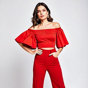 Confident Woman in Red Off-Shoulder Crop Top and High-Waisted Pants