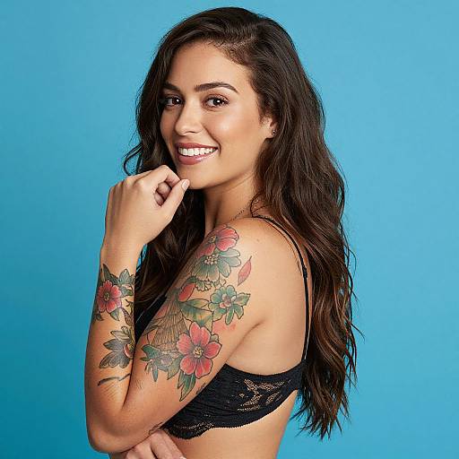 Confident Woman with Floral Tattoos and Wavy Hair on Blue Background