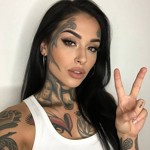Tattooed Woman Making Peace Sign Wearing White Tank Top