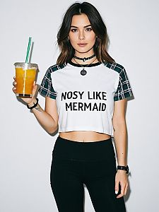 Woman Wearing White Cropped Graphic T-Shirt with Black Neckline and Plaid Sleeves
