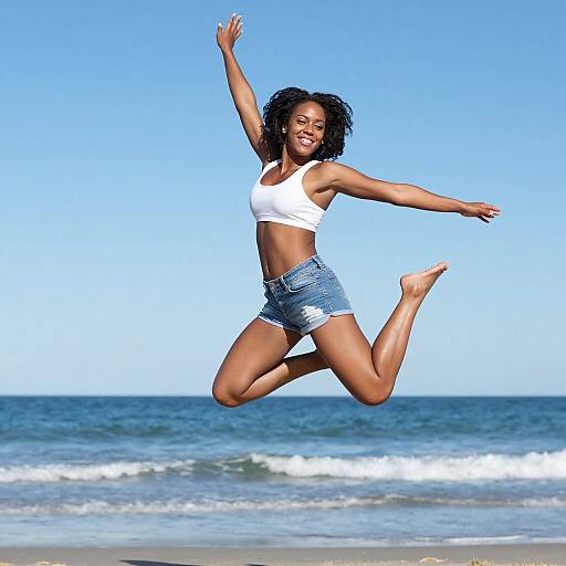 Joyful Woman Jumping on Beach in White Top and Denim Shorts