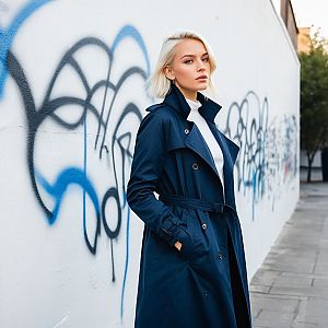 Stylish Woman in Navy Trench Coat Against Graffiti Wall