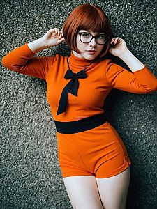 Stylish Young Woman in Orange Romper with Red Bob Haircut