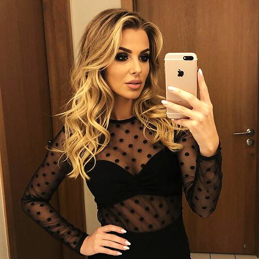 Stylish Woman Taking Mirror Selfie in Sheer Black Polka Dot Top