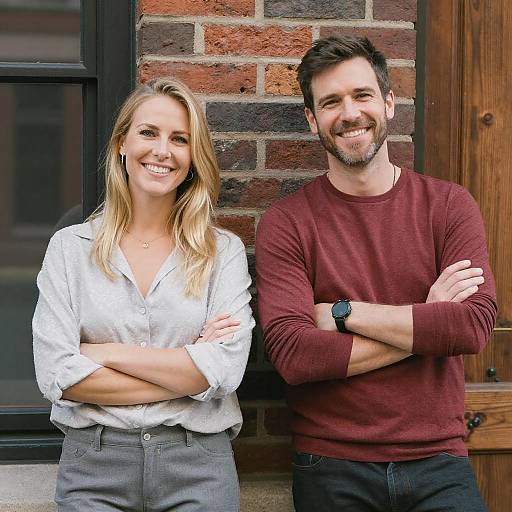 Happy Young Woman and Man Smiling Outdoors Leaning on Brick Wall