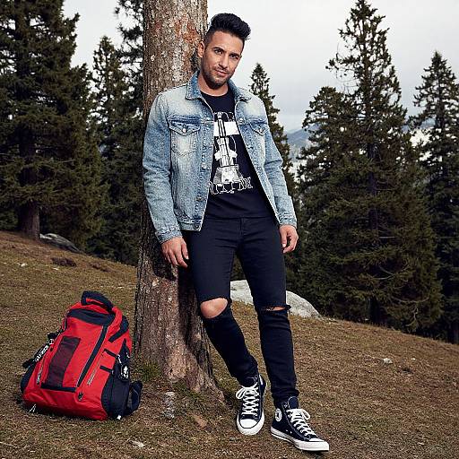 Stylish Man Leaning on Tree with Red Backpack in Forest