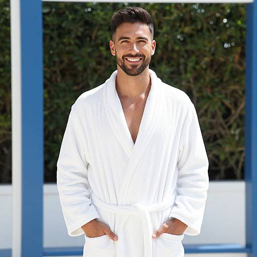 Smiling Man in White Bathrobe Outdoors with Greenery Background