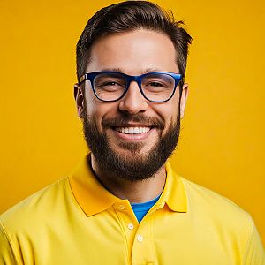 Cheerful young man in yellow polo with beard and glasses