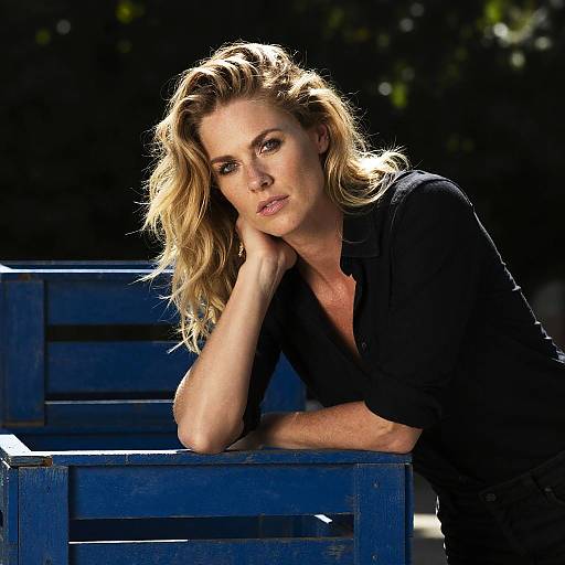 Blonde Woman Leaning on Blue Wooden Structure in Natural Light