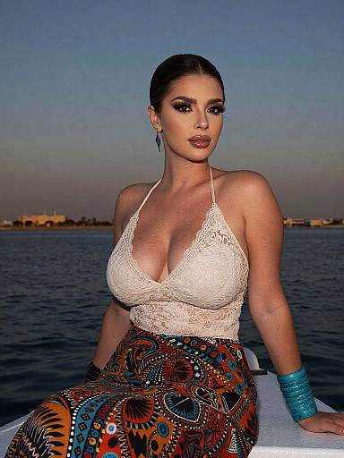 Bohemian Woman Wearing Cream Lace Top and Colorful Patterned Skirt by the Water