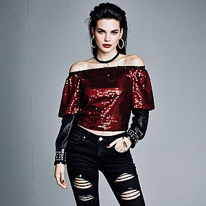 Confident Woman in Burgundy Sequin Top and Black Ripped Jeans Fashion Portrait
