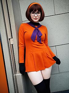 Confident Woman in Orange Dress with Bow Tie