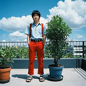 Young Man in Rooftop Garden with Potted Plants