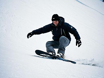 Man Snowboarding on a Snowy Slope