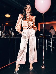 Elegant Woman in Satin Outfit with Pink Balloon at Nightclub