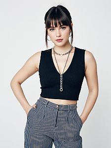 Woman in Contemporary Casual Black Ribbed Crop Top with Deep V Neck and Striped Pants