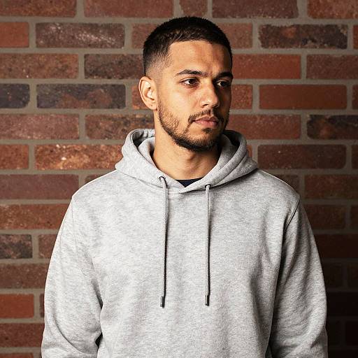 Young Man Wearing Gray Hoodie Against Brick Wall