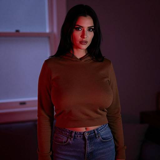 Portrait of Young Woman in Brown Cropped Hoodie with Red and Purple Lighting