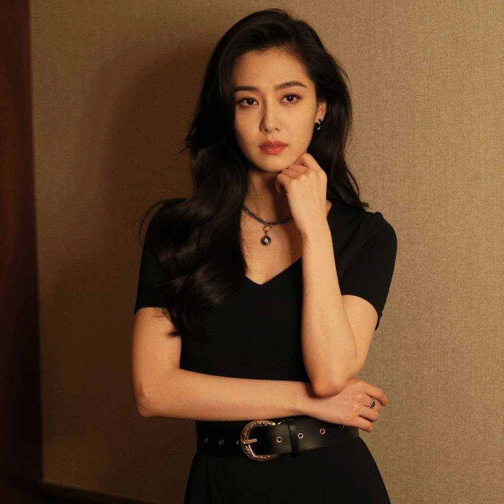 Elegant Young Woman in Black Dress with Wavy Hair Portrait