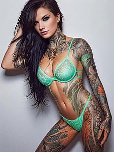 Confident Woman with Intricate Tattoos in Mint Green Lingerie
