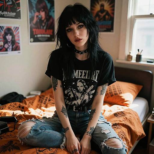 Grunge Woman Sitting on Bed Wearing Ripped Jeans and Graphic Tee