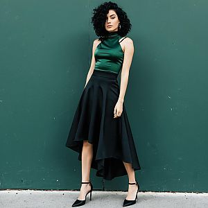 Stylish Woman in Green Satin Top and High-Low Black Skirt Fashion Portrait