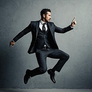 Dynamic Portrait of Man in Black Suit Jumping Against Gray Background