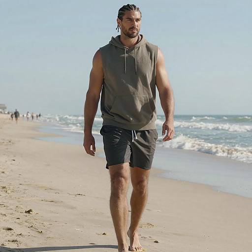 Man Walking Barefoot on Beach in Sleeveless Hoodie and Shorts