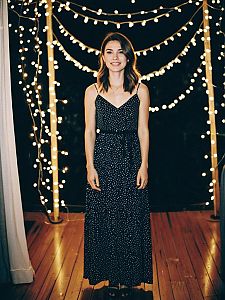 Young Woman in Polka Dot Dress with Festive String Lights Indoors