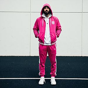 Man in Pink Tracksuit Against Wall