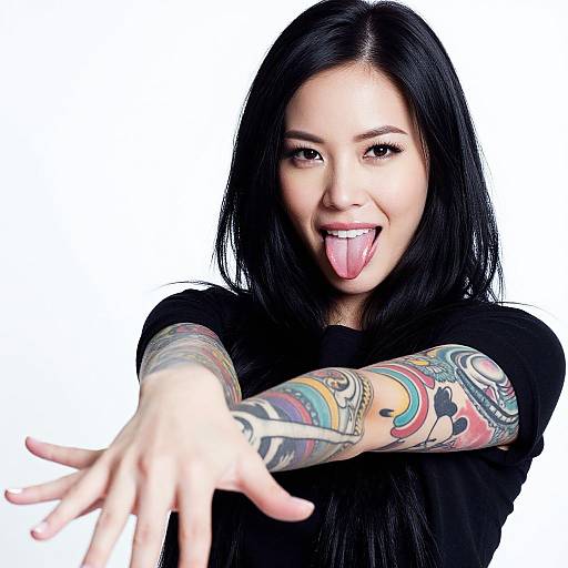 Playful Young Woman Showing Colorful Sleeve Tattoos Sticking Tongue Out