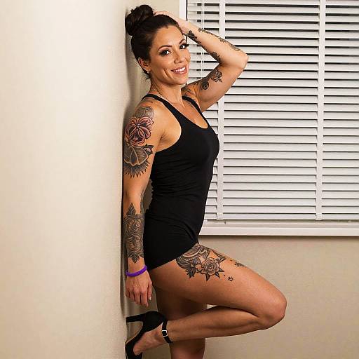 Confident Tattooed Woman in Black Dress Posing Indoors