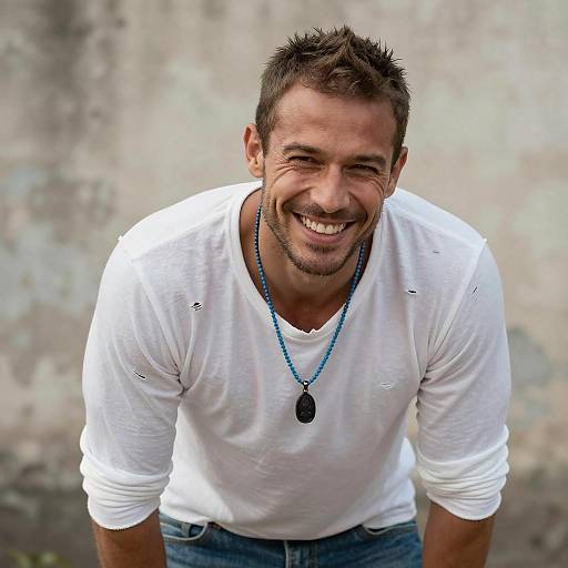 Smiling Young Man in Casual White Shirt with Blue Beaded Necklace
