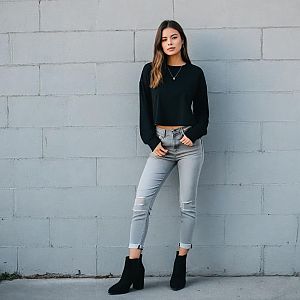 Stylish Woman in Casual Outfit Posing Against Gray Wall