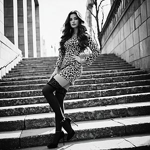 Confident Woman in Patterned Dress on Staircase