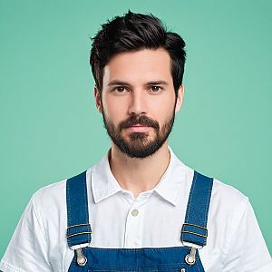 Young Man in Denim Overalls Against Teal Background