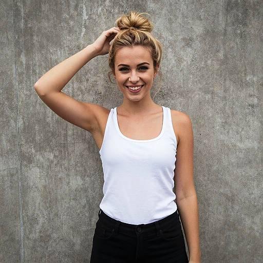 Smiling Young Woman in White Tank Top Against Concrete Wall - Gen Z Style