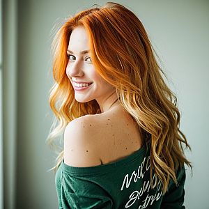 Red-haired woman in green top, smiling