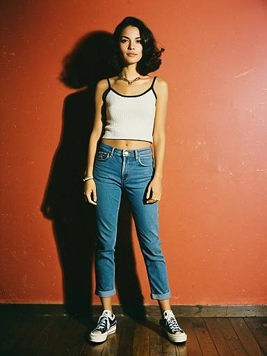 Woman in Casual Chic Cropped White Tank Top with Thin Straps and Blue Jeans