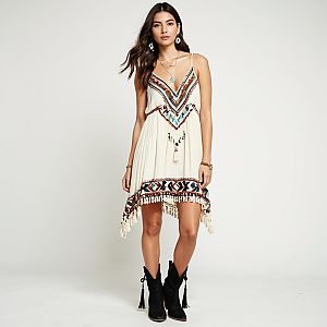 Boho Chic Woman Wearing Cream Colored Embroidered Mini Dress with Tassels